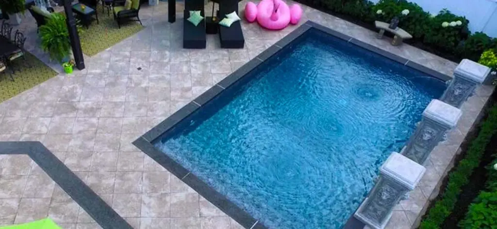Aerial view of a pool with pillar water features and dark coping